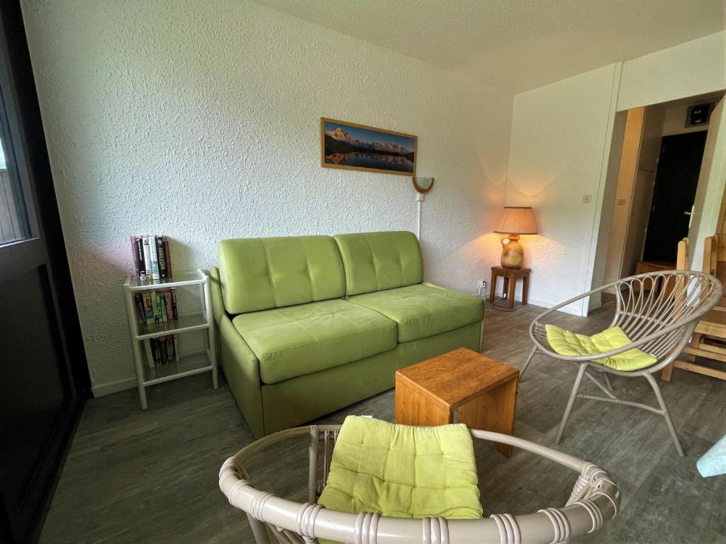 un salon avec un canapé vert et une table dans l'établissement Appartement pour 6 pers, 38m², balcon sud, au pied des pistes, Les Menuires Croisette - FR-1-452-179, aux Menuires