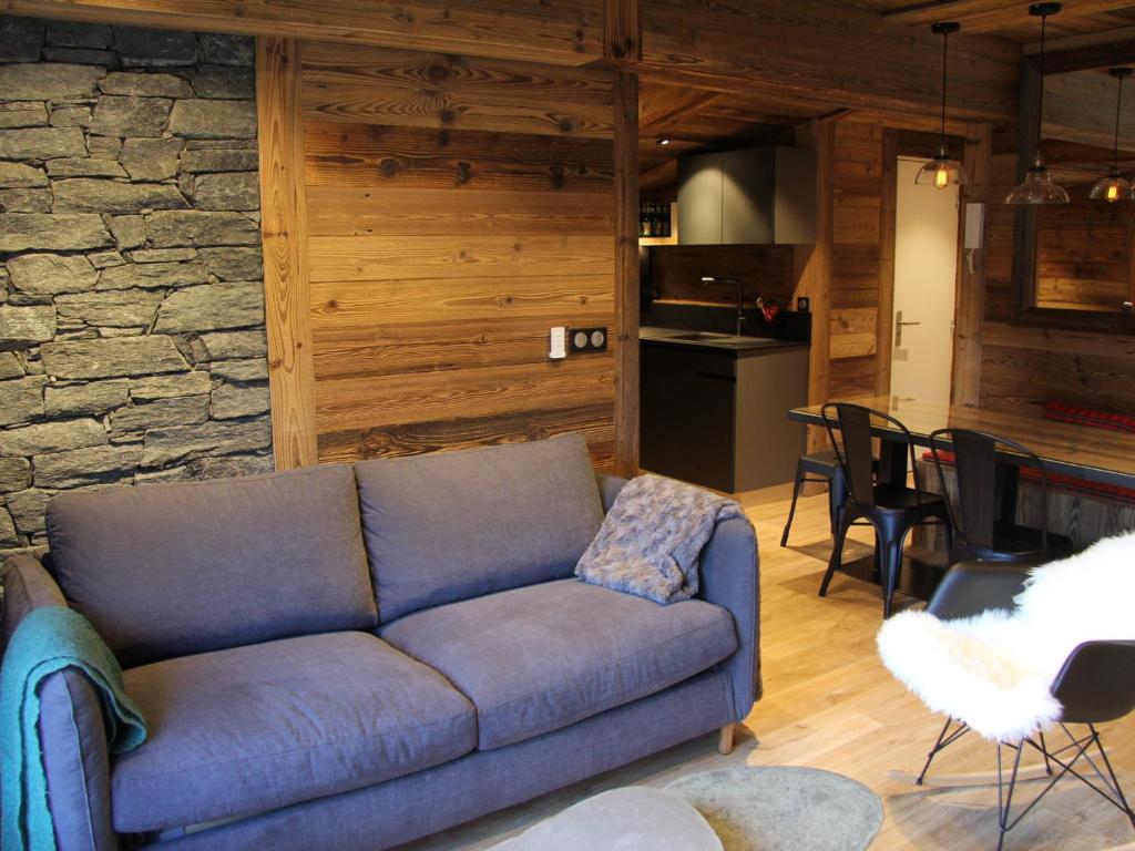 a blue couch in a living room with a kitchen at Appartement La Clusaz, 3 pièces, 6 personnes - FR-1-459-136 in La Clusaz