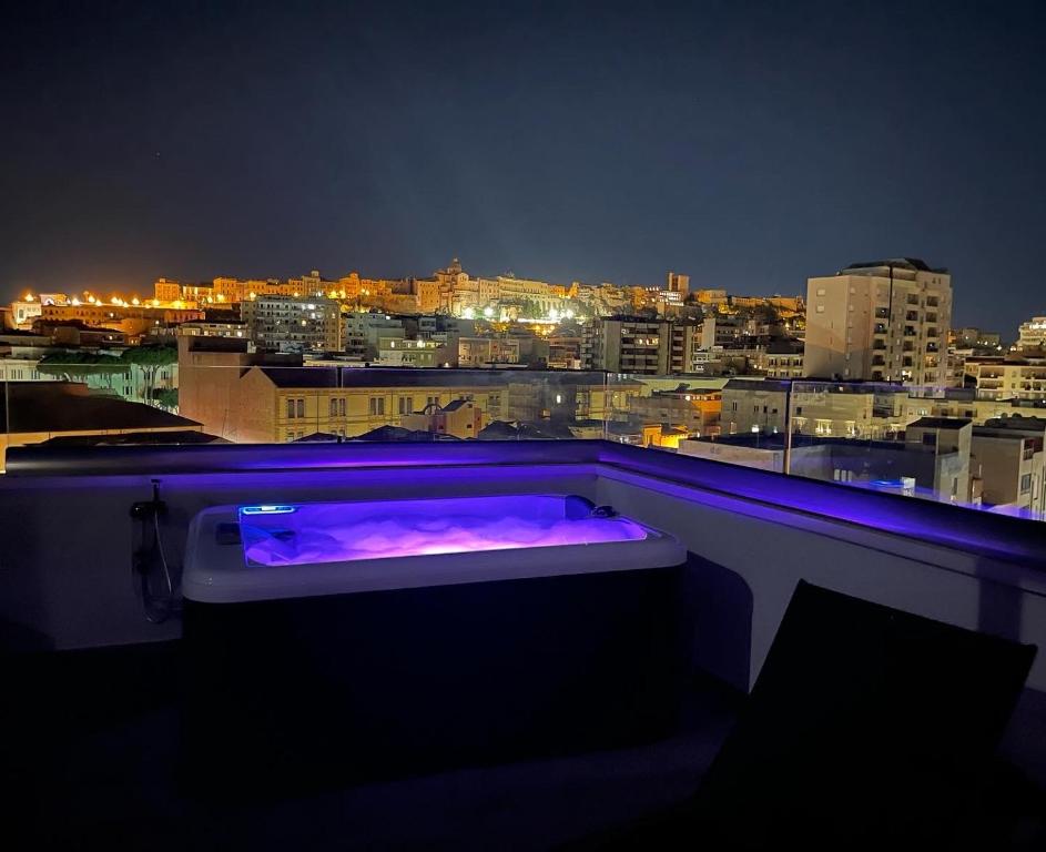 eine Badewanne auf dem Balkon in der Nacht in der Unterkunft 18 Dante Luxury Suites in Cagliari