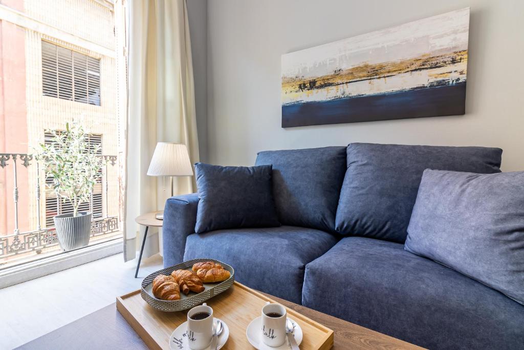 niebieską kanapę w salonie ze stołem w obiekcie Malaga Center Flat - SoHo Center Apartments w Maladze