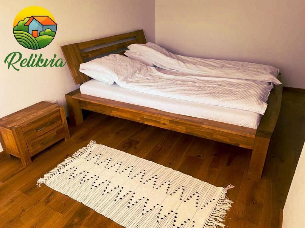 1 dormitorio con cama con marco de madera y alfombra en Relikvia, en Sovata