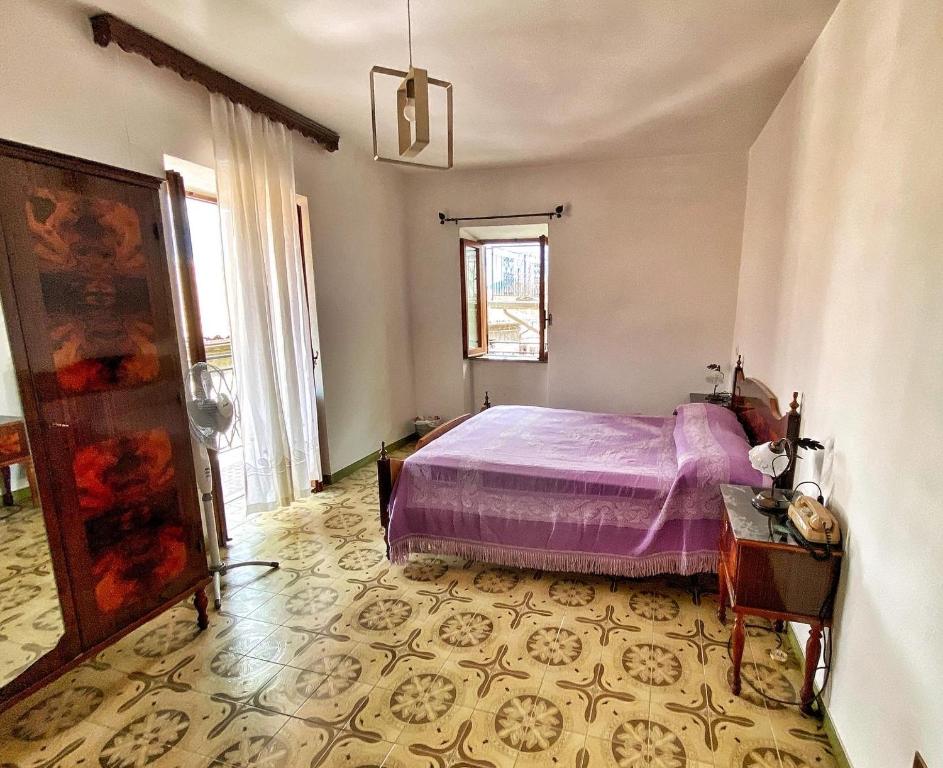 a bedroom with a purple bed in a room at Elle Shelter in Scanzano