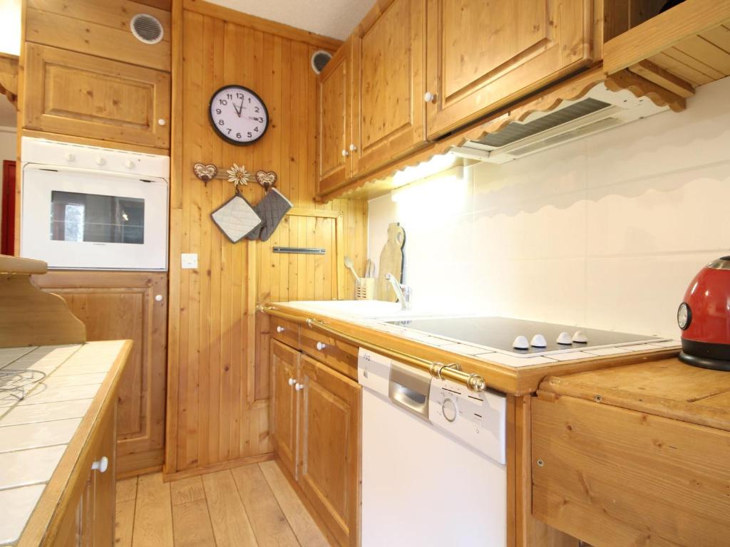 kuchnia z drewnianymi szafkami i białą zmywarką do naczyń w obiekcie Appartement Rénové au Centre, Balcon Sud-Ouest, Wifi Gratuit, Proche Pistes et Commerces - FR-1-346-319 w mieście Arc 1800