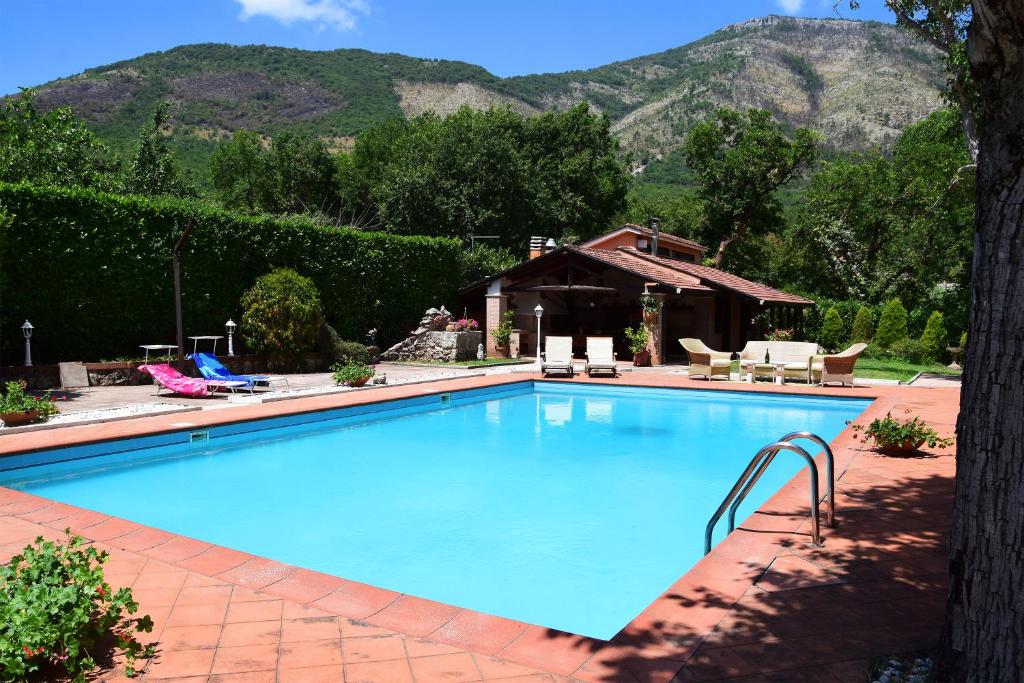 una gran piscina azul con montañas en el fondo en Casale Santa Croce, en Pastena