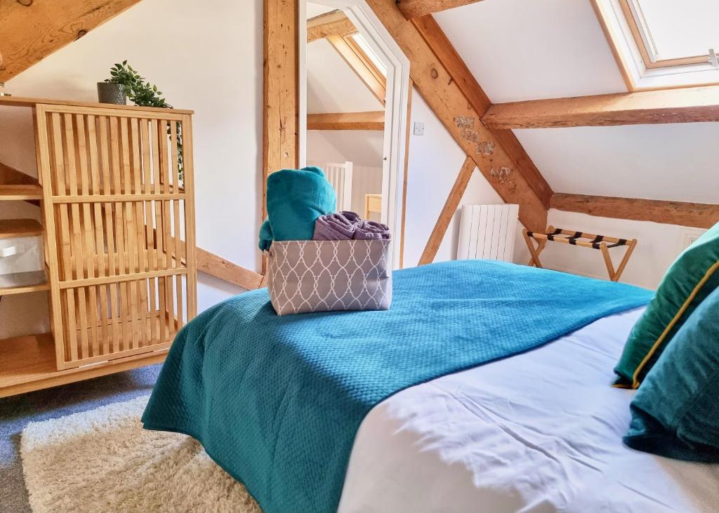 a bedroom with a bed with a blue blanket at Eldon Row - Stylish Character Apartments - Central Location 1 & 2 bed available in Dolgellau