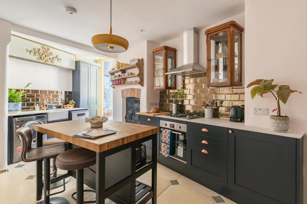 uma cozinha com uma mesa de madeira e um fogão forno superior em Merchants Town House - Catherine Hill em Frome