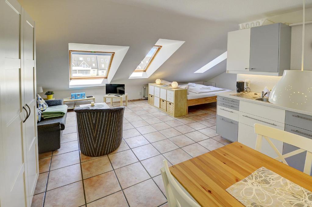 a kitchen and a living room with a table at fewo1846 Strandresidenz Wassersleben - Kleine Meerjungfrau - komfortables Studioapartment im Dachgeschoss in Harrislee