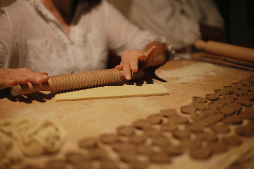 a person holding a rolling pin next to cookie dough at Borgo Egnazia in Savelletri di Fasano