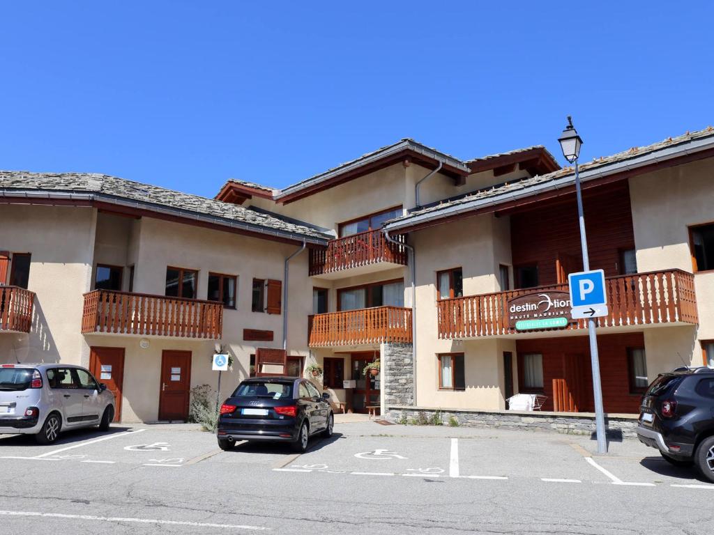 a parking lot with cars parked in front of a building at Appartement Aussois, 2 pièces, 4 personnes - FR-1-508-68 in Aussois