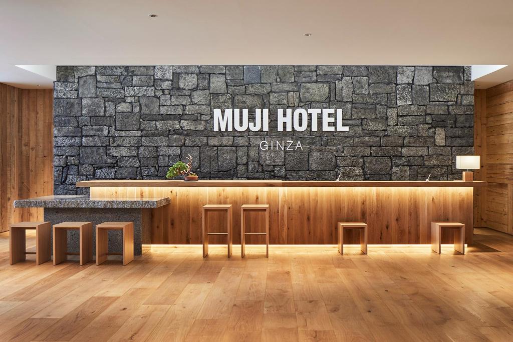 a lobby of a hotel with a stone wall at MUJI HOTEL GINZA in Tokyo
