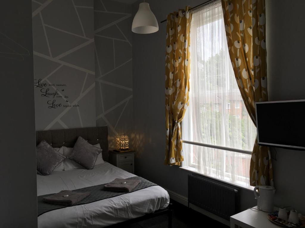 En eller flere senge i et værelse på Queens Guesthouse Manchester