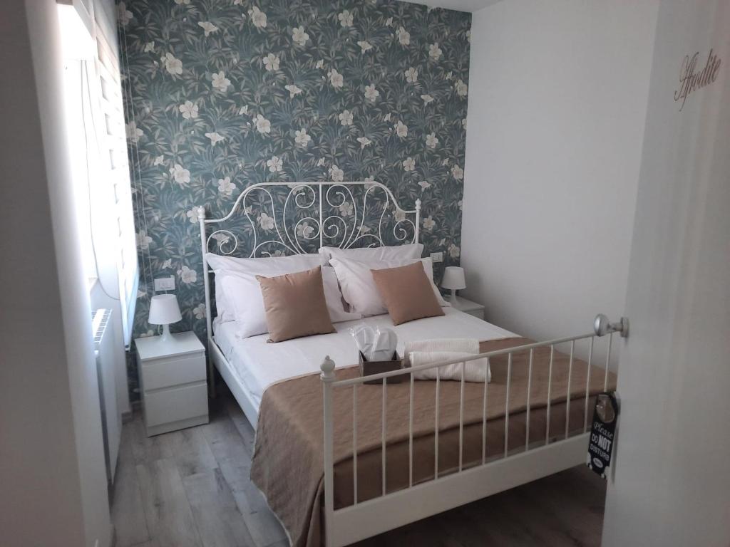 una camera da letto con un letto con carta da parati floreale di GUEST HOUSE TRA CIELO E MARE a Nettuno