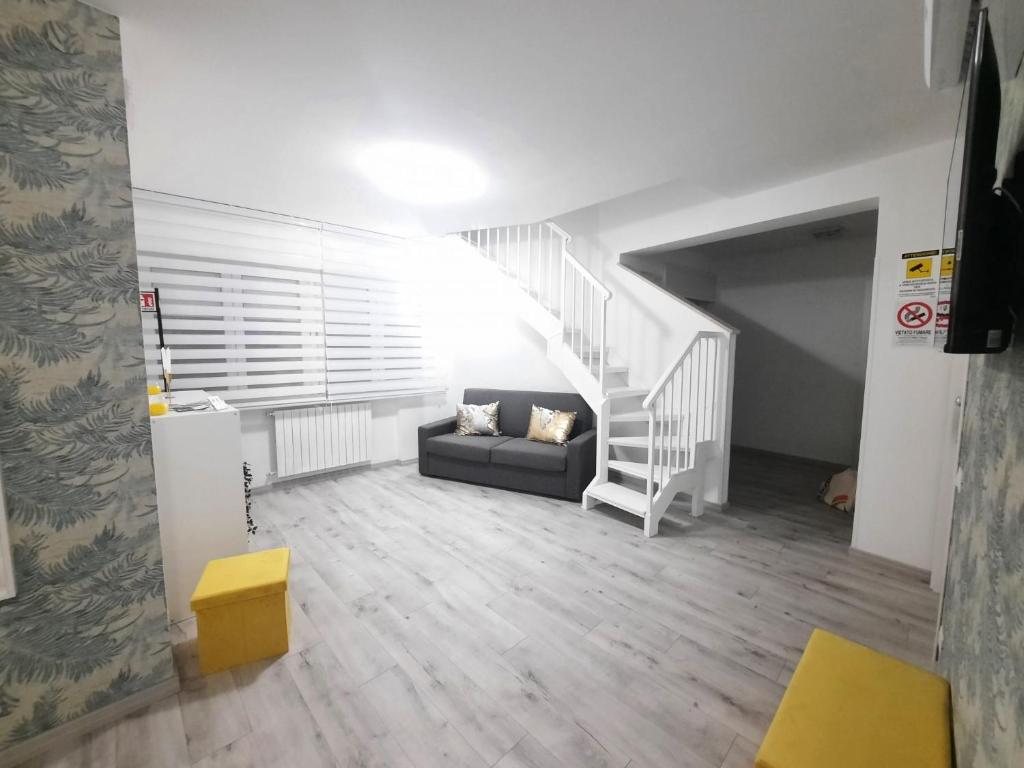 un soggiorno con un divano e una scala di GUEST HOUSE TRA CIELO E MARE a Nettuno