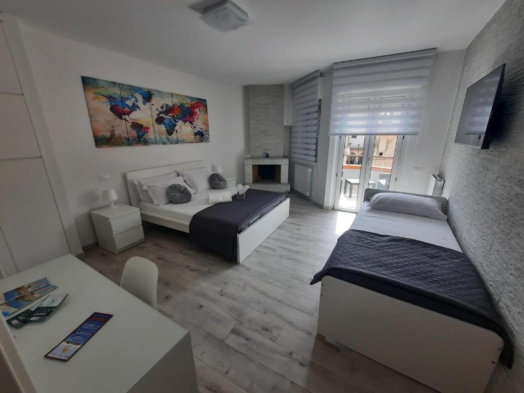un soggiorno con 2 letti e un tavolo e una camera di GUEST HOUSE TRA CIELO E MARE a Nettuno