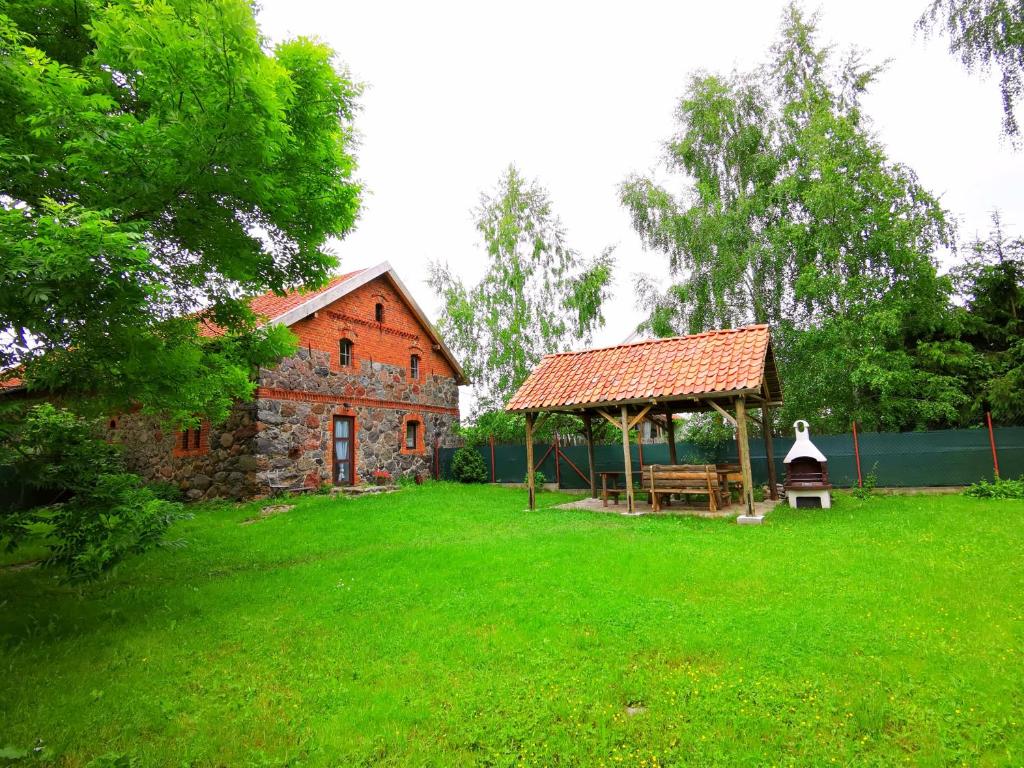 un edificio con cenador en un patio en Mazurski Ogród - dom z ogrodem, kominkiem i wiatą biesiadną en Wydminy
