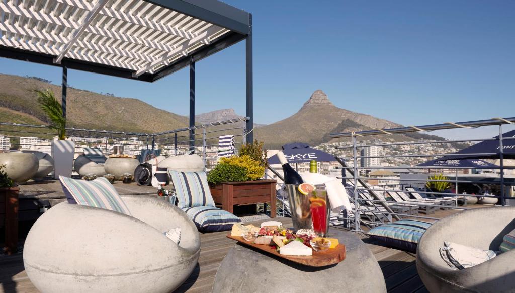 a balcony with chairs and a tray of food on a table at The Hyde All Suite Hotel in Cape Town