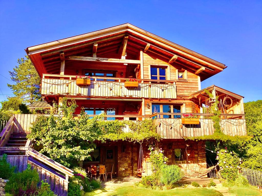 a large wooden house with a balcony at Chalet du Silberrain près de Colmar - cheminée, sauna, piscine partagée in Osenbach