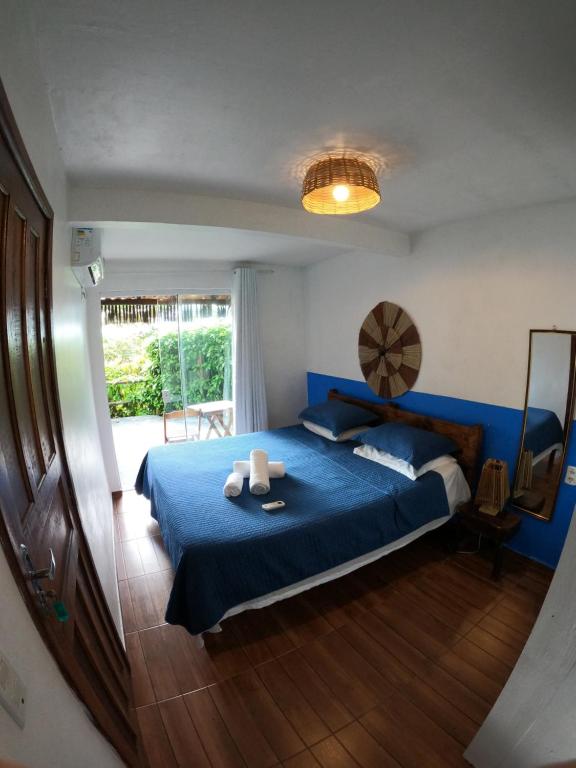 a bedroom with a blue bed and a window at Pousada Pipe House in Itacaré
