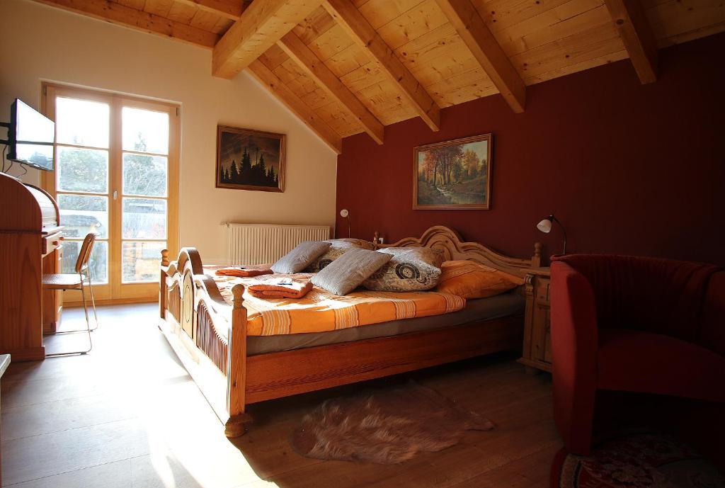 1 dormitorio con cama de madera en una habitación en Pension und Falknerei an der alten Schmiede, en Bernstadt