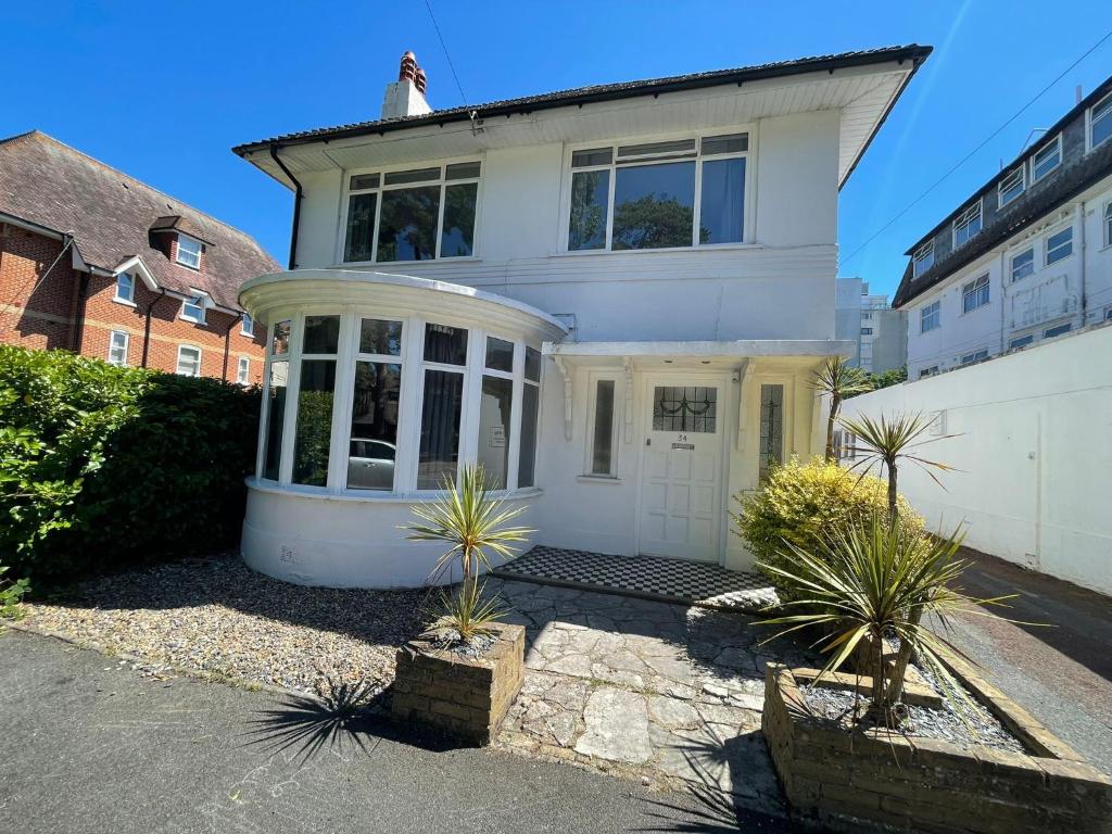 una casa blanca con plantas delante en Bayside GuestHouse en Bournemouth