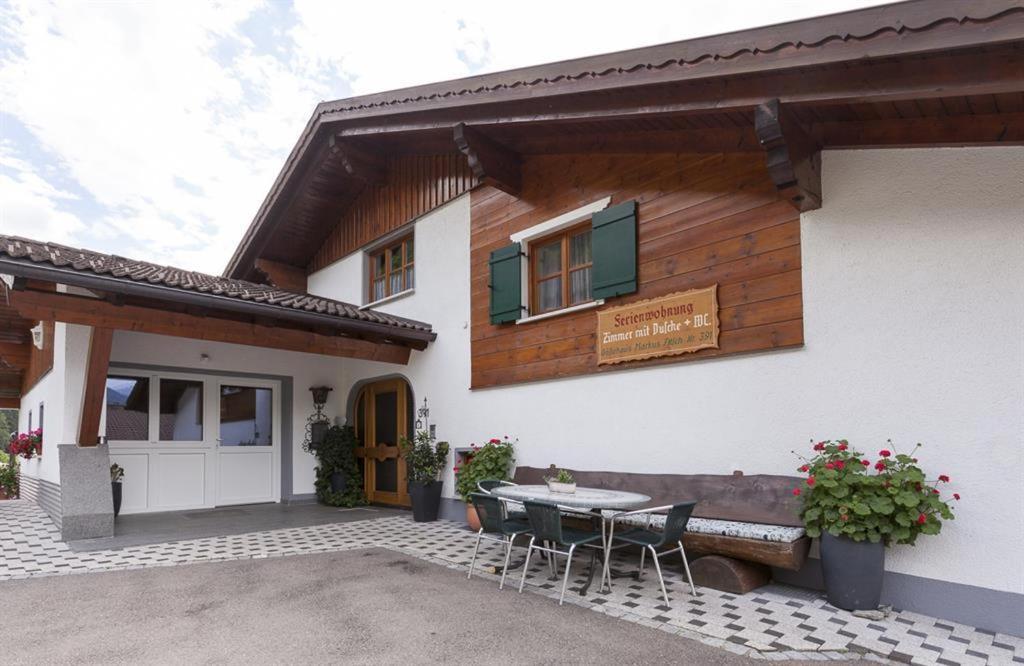 a house with a patio with a table and chairs at Gästehaus Fitsch - Ferienwohnung in Silbertal in Silbertal