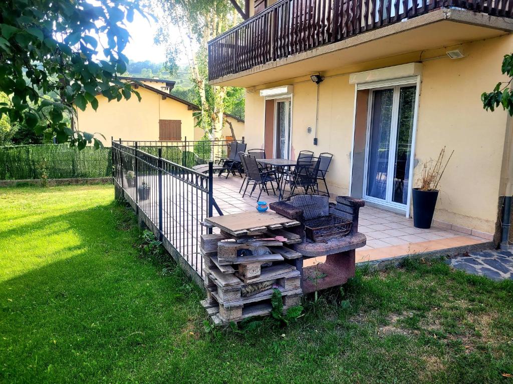 taras ze stołem i krzesłami na domu w obiekcie Maison de vacances au cœur de la Cerdagne w mieście Angoustrine
