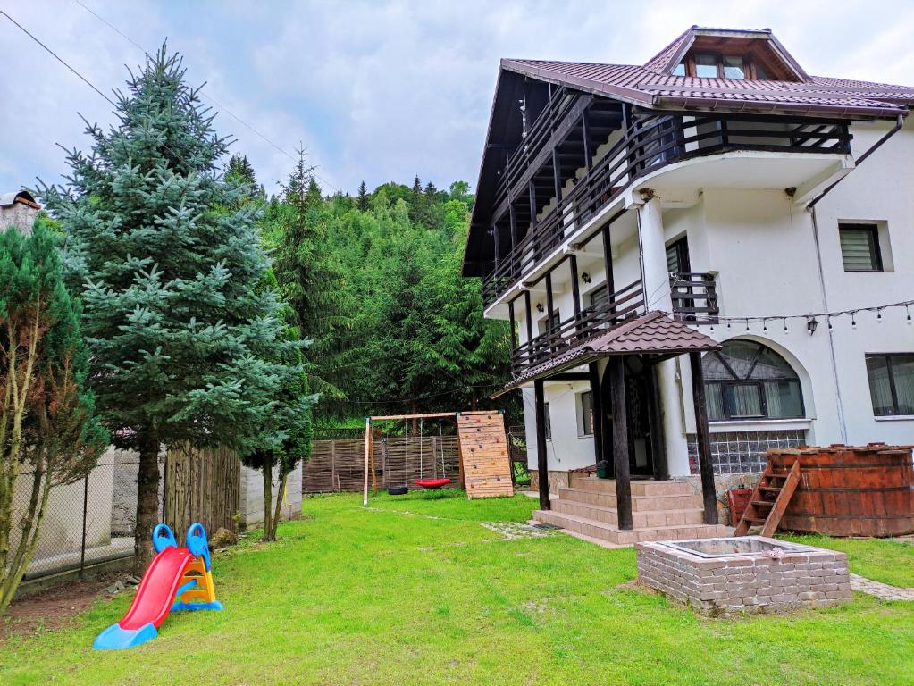 una casa con un parque infantil delante de ella en CASA HAIDUCILOR SATIC, en Rucăr