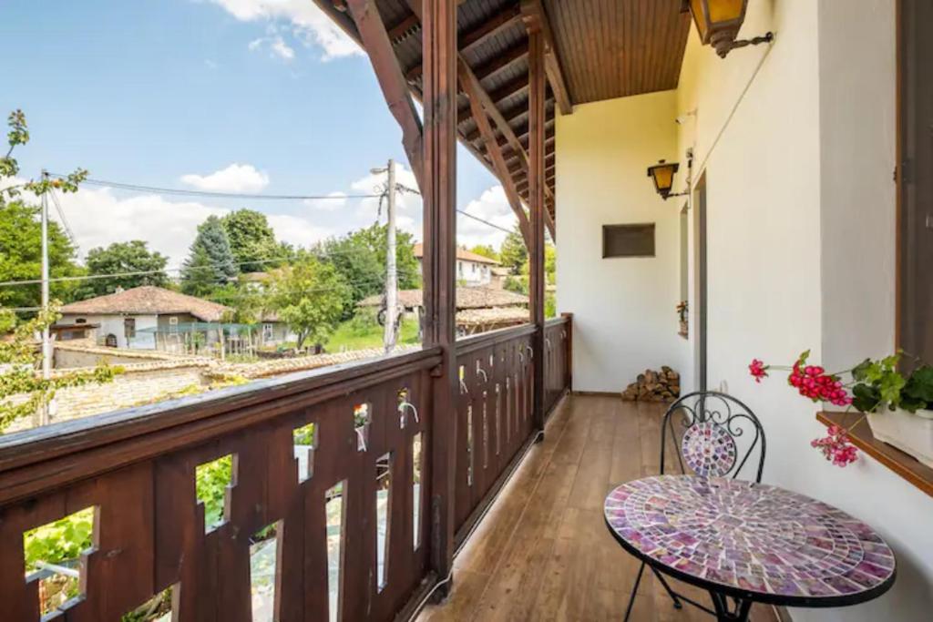 uma varanda com uma mesa e uma vista em Guest House Geranium Arbanasi em Arbanasi