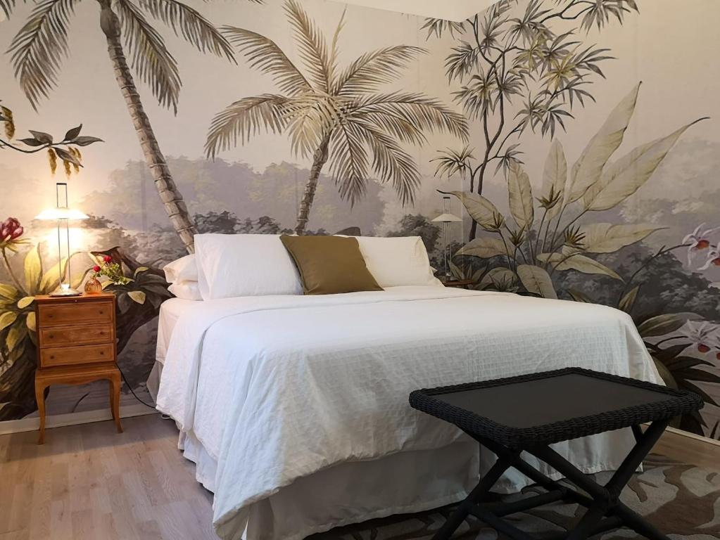 a bedroom with a bed with palm trees on the wall at Los Murillos II in Las Palmas de Gran Canaria