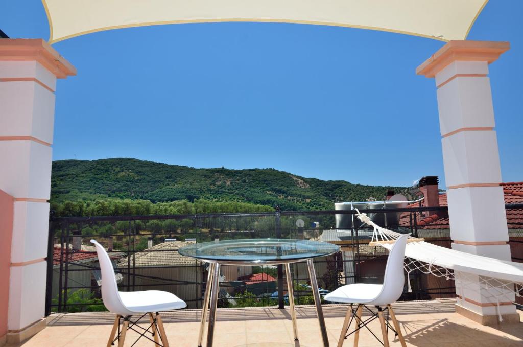 - Balcón con mesa de cristal y 2 sillas en Villa Ektoras by EY Villas en Parga