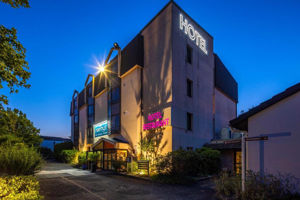 un bâtiment avec un panneau indiquant l'hôtel dans l'établissement Noemys Brive - ex Hôtel Restaurant Le Teinchurier, à Brive-la-Gaillarde