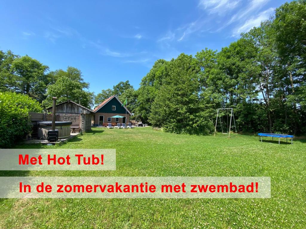 een grote tuin met een huis en een speeltuin bij Het Achterhoeks Voorrecht in Aalten