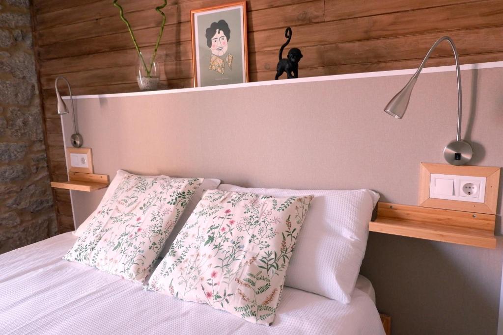 Sas de Penelas的住宿－A casa da Penela，一张带木制床头板和两个枕头的床