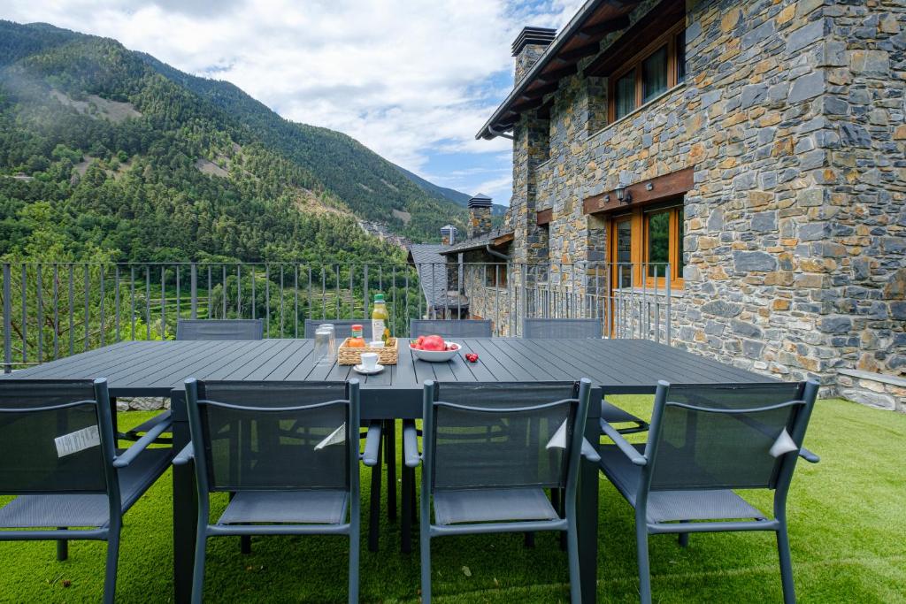 a table and chairs in front of a stone house at Quiet House Sa Calma in Andorra la Vella