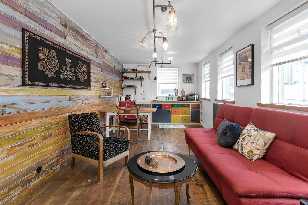 a living room with a red couch and a table at Rustic Retreat in the Center of Reykjavik in Reykjavík