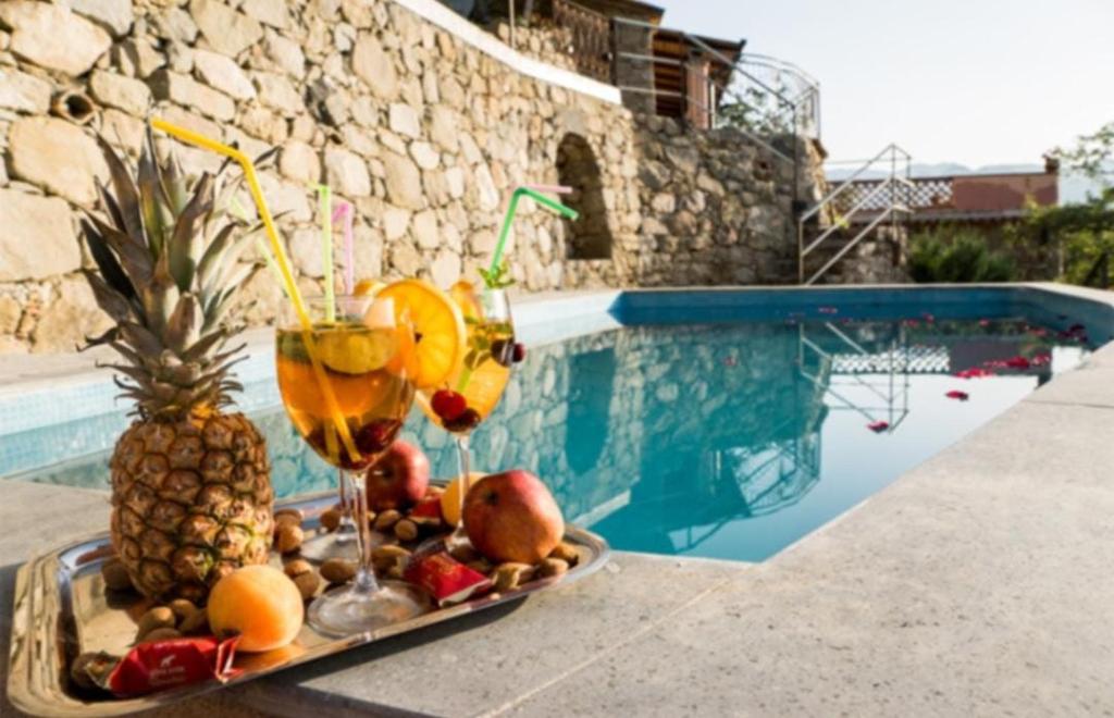 uma bandeja de frutas numa mesa ao lado de uma piscina em Villa Jewels ,casa vacanza em Gaggi