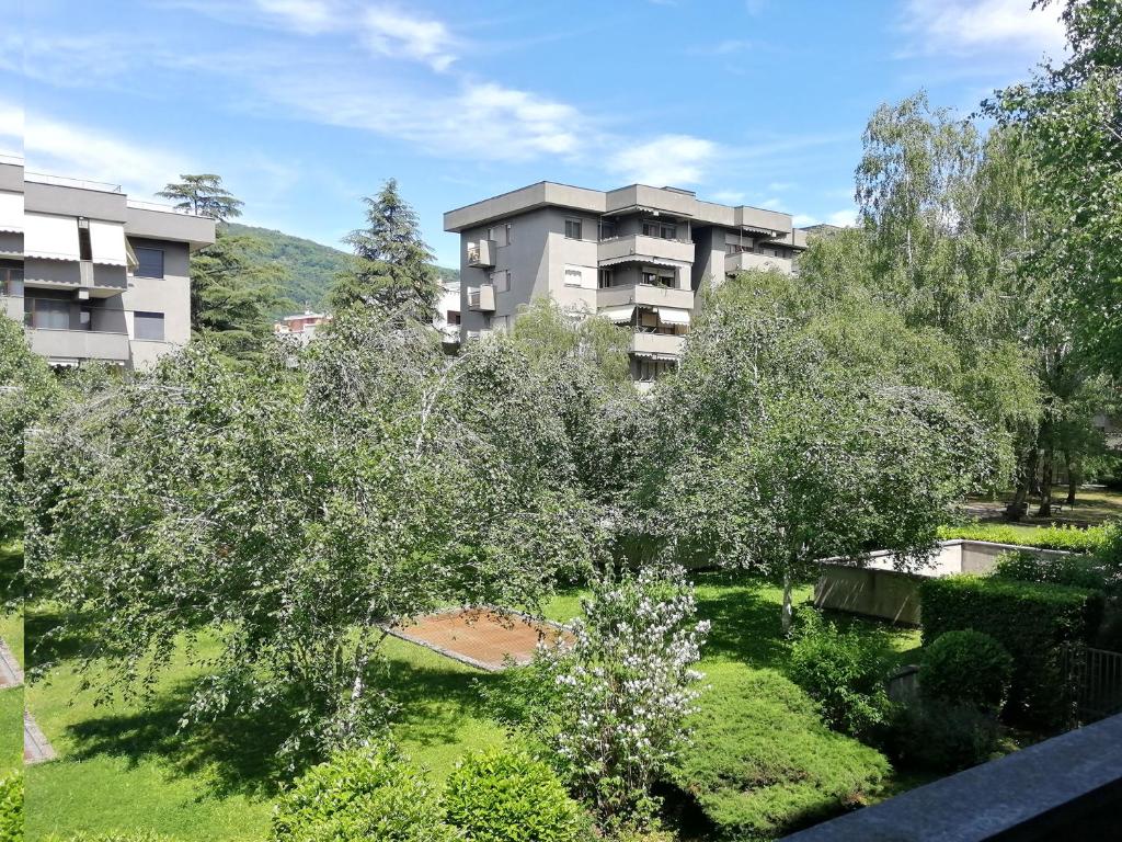 an apartment building with trees in front of it at Como Sole, green and quiet in Como