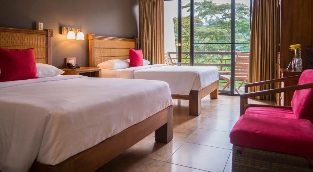 um quarto de hotel com duas camas e uma varanda em Hotel Ladera em Boquete