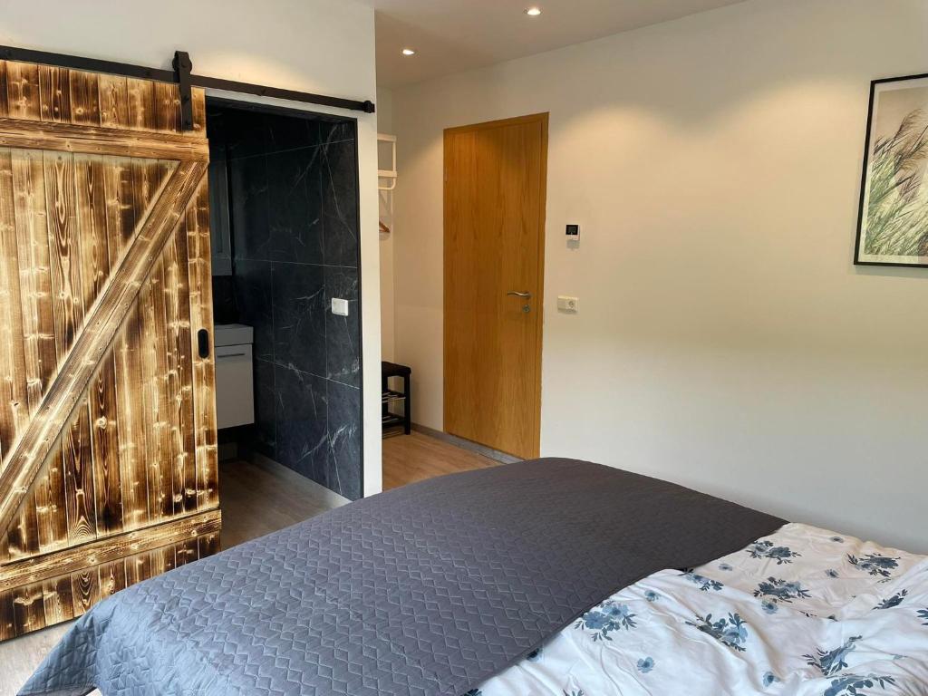 1 dormitorio con 1 cama y puerta de madera grande en Vestmannsvatn Guesthouse en Aðaldalur