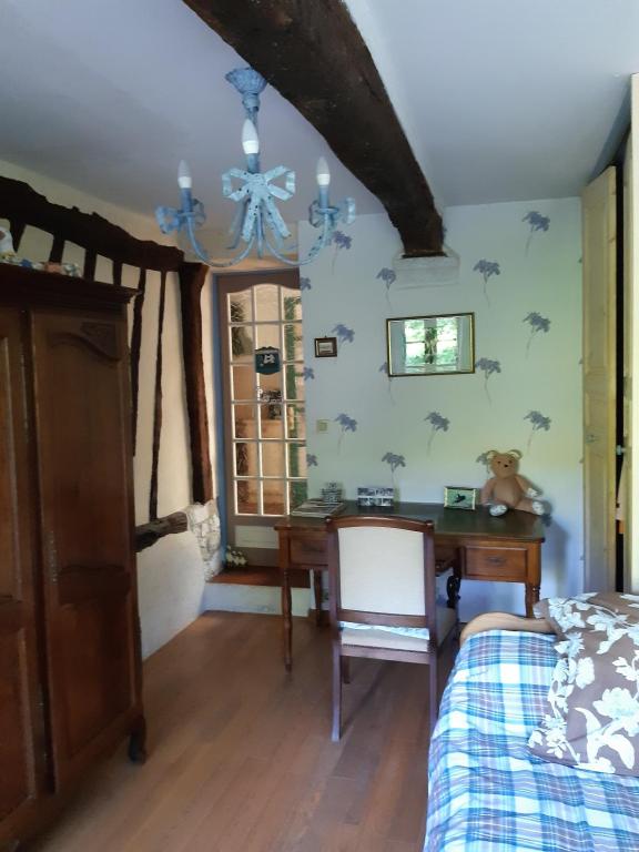 a bedroom with a desk and a bed and a table at les orchidees sauvages in Touffreville-la-Corbeline