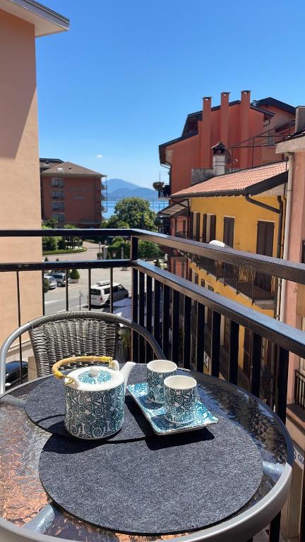 una mesa con 2 tazas en la parte superior de un balcón en B&B Gloria Apartment, en Baveno