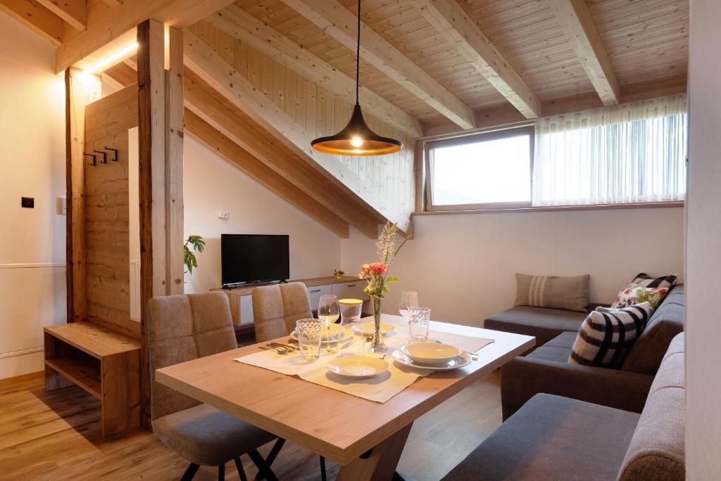 comedor y sala de estar con mesa de madera en Apartment Schöne Aussicht, en Maranza
