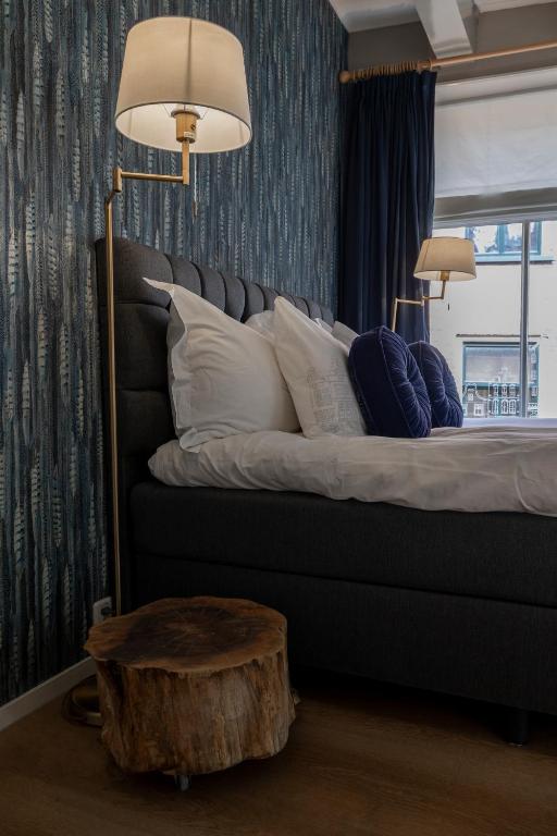 a bedroom with a bed with pillows and a table at Sterlogies City Apartment Monsieur Philippe in Leeuwarden