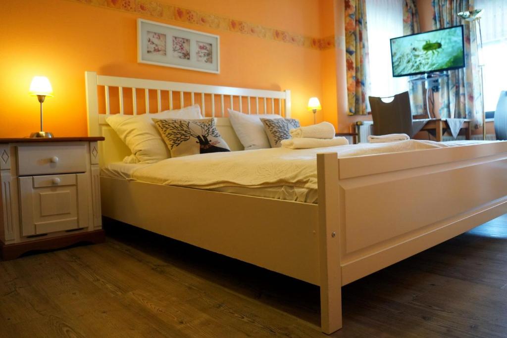een slaapkamer met een groot wit bed met kussens bij Zimmer Nr 2 im Haus Sabine in Braunlage