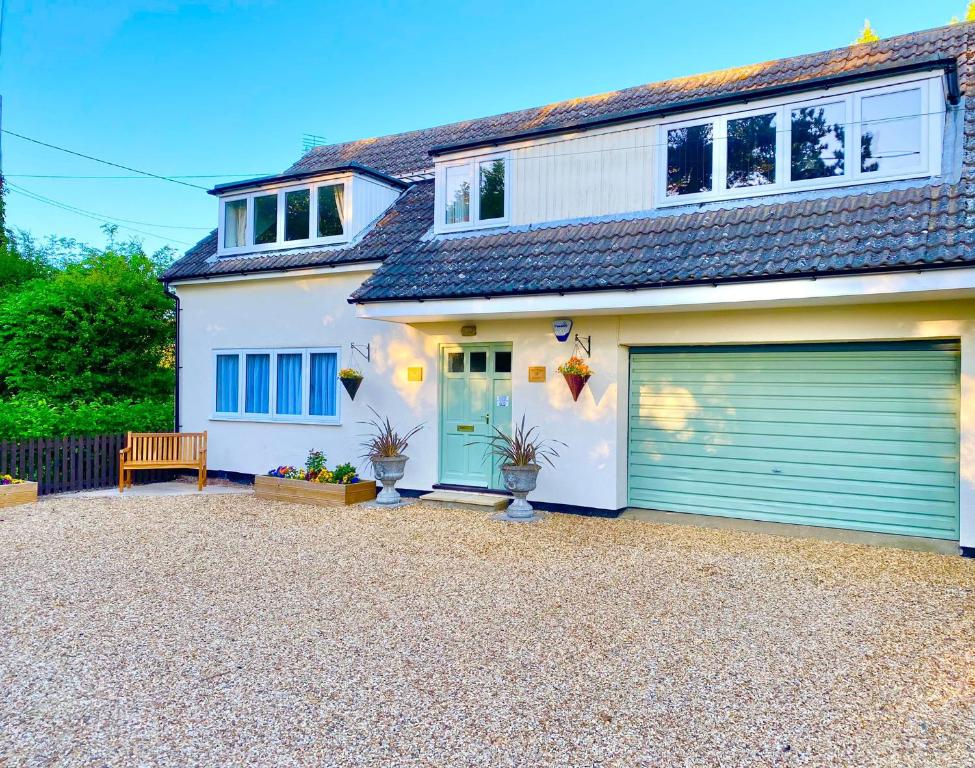 uma casa branca com uma porta de garagem verde em Peaceful Country Cottage - views/walks - New 2022 em Lincoln