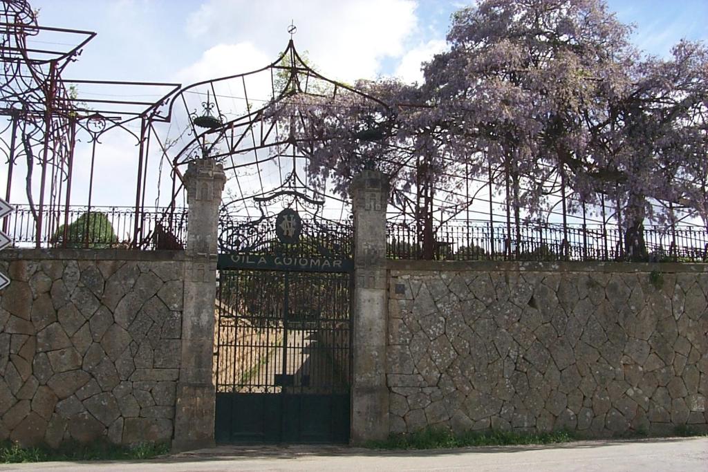 a wrought iron gate with a stone wall at Vila Guiomar - Casa da Eira in Alvarenga