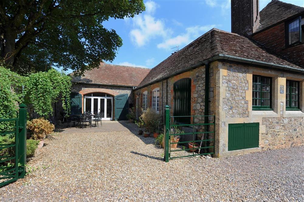 an old brick building with a green gate in front of it at The Forge in Rousdon