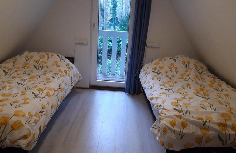 twee bedden in een kamer met een raam bij Vakantiehuis op top locatie #Ommen in Ommen