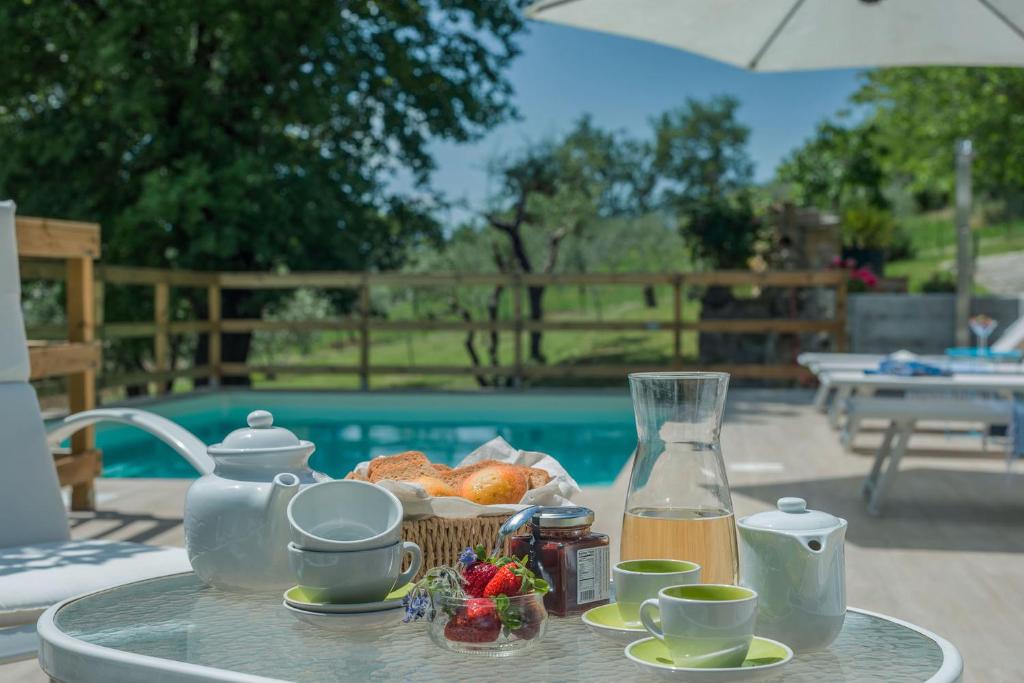 uma mesa de vidro com uma bandeja de comida e uma bebida em Casa Claudia 7 em San Lorenzo in Campo