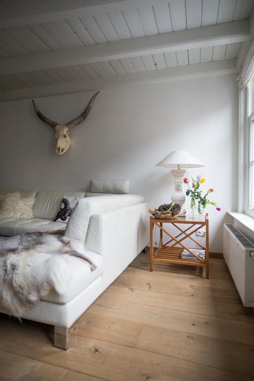 a white bedroom with a bed and a table at Sterlogies De Rozenboom in Leeuwarden